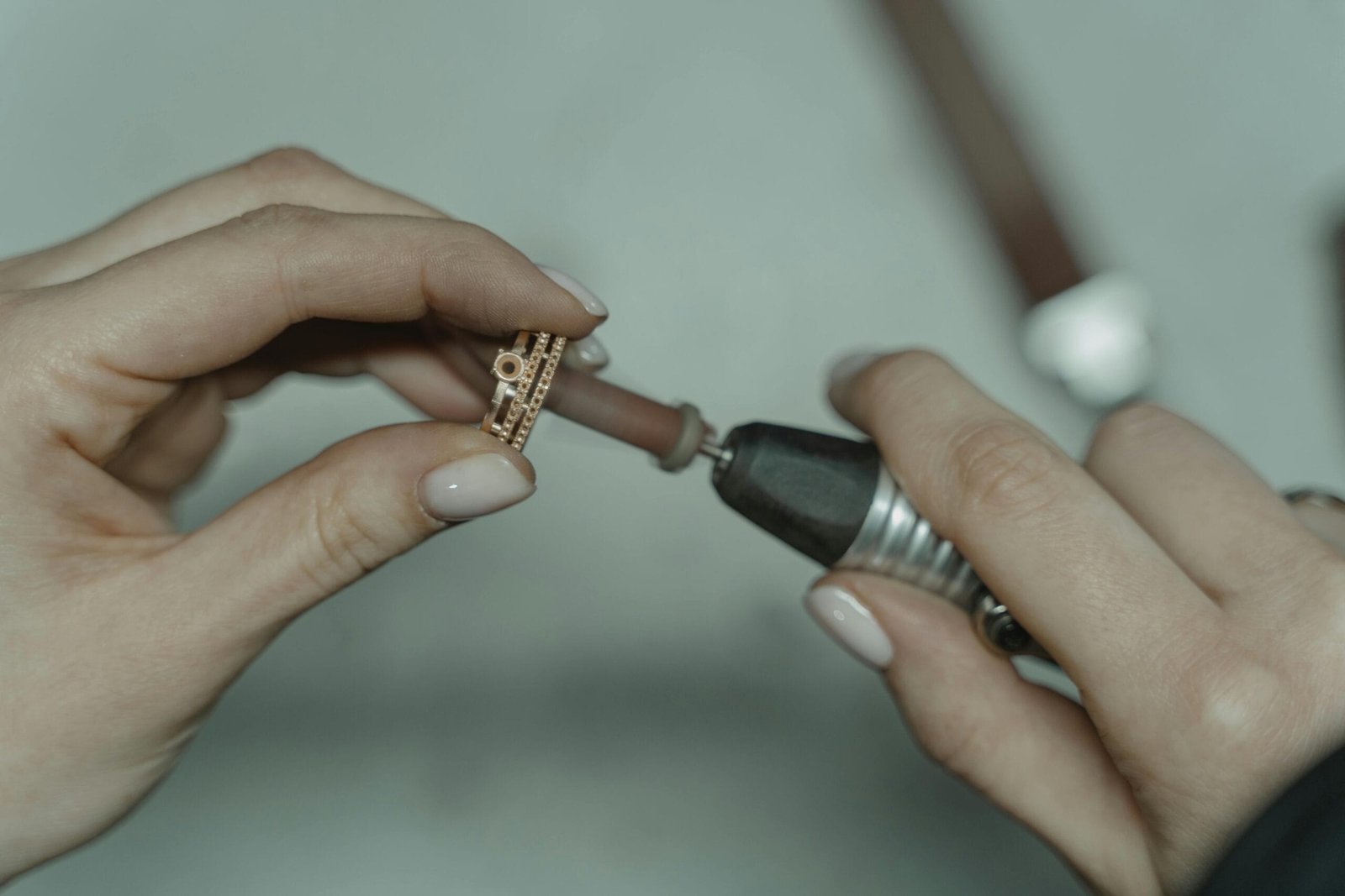 Detailed image of crafting jewelry with precision tools indoors.